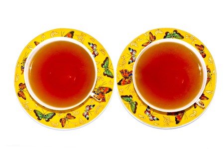 Two yellow cups of tea with varicoloured butterfliesの写真素材