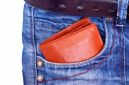 Brown wallet in blue jeans pocket on white background