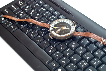 Compass on black keyboard. Isolated on white backgroundの写真素材