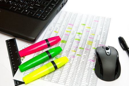 Close-up of notebook, mouse, pens and rule on paper table.