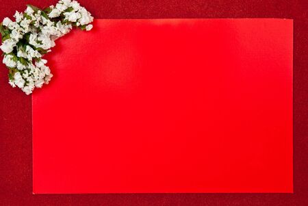 Red greeting card on red background with flowers designの写真素材