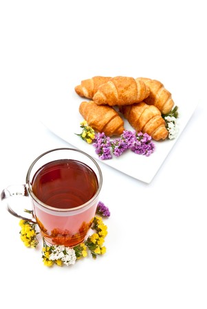Tea and croissants with flowers design isolated on whiteの写真素材
