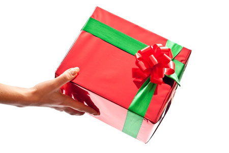 Woman's hand with a small red gift box isolated on white background