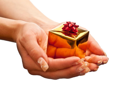 Woman's hand with a small gold gift box with red bow isolated on white background
