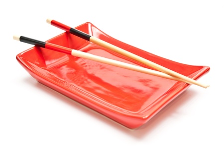 Black and red chopsticks and plate. White backgroundの写真素材