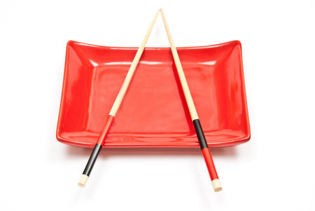 Black and red sushi set (chopsticks and plate) isolated on white backgroundの写真素材