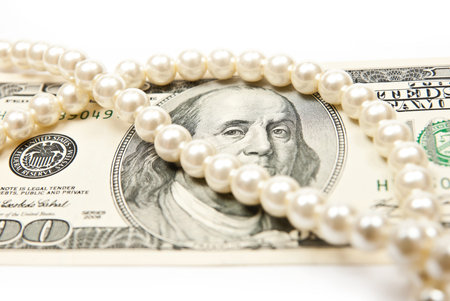 Pearls and dollars on white background