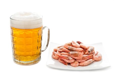 Fresh, cold beer in glass and fried shrimps on plate. Isolated on whiteの写真素材