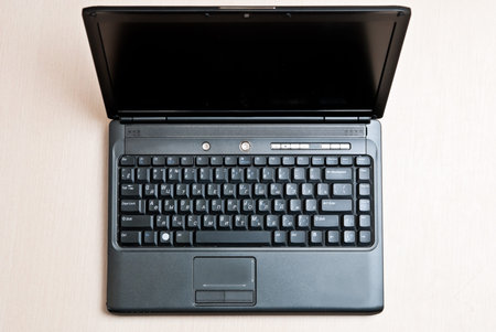 Black laptop on an office wood desk