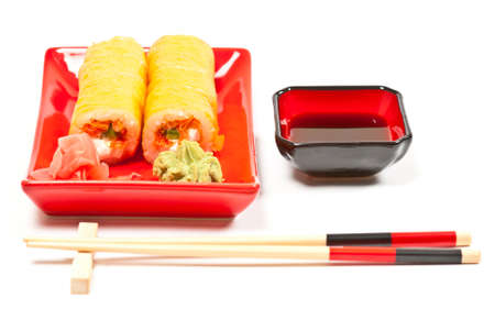 Yellow sushi rolls served on a plate. White backgroundの写真素材