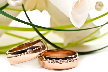 Pair of golden wedding rings with rose bouquet. Macro photo Pair of golden wedding rings with rose bouquet. Macro photo