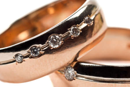 Macro photo of gold wedding rings with diamonds. White background.の写真素材