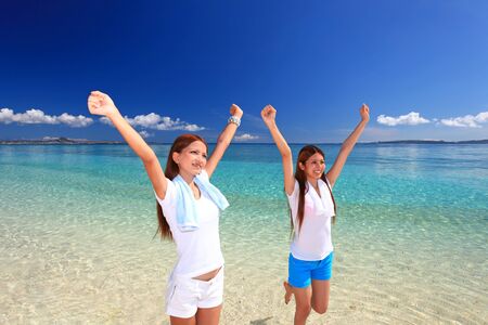 young woman doing stretching exercises on beachの写真素材