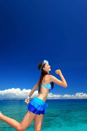 young woman doing stretching exercises on beachの写真素材