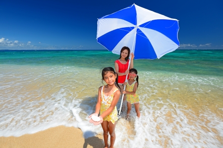 Family playing on the beach in Okinawaの写真素材