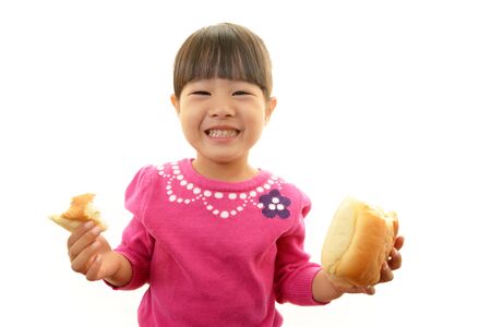 Little girl eating breadの写真素材