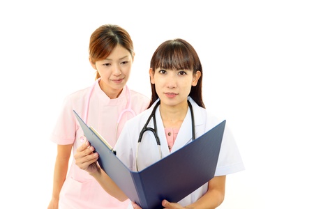 Professional hospital staff working on a note pad together Professional hospital staff working on a note pad together