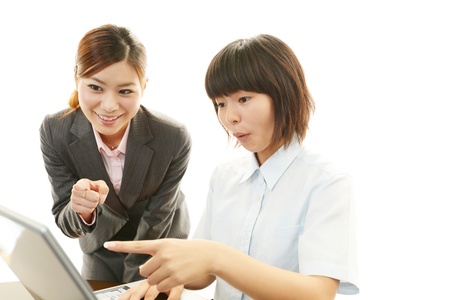 Smiling girls using a laptopの写真素材