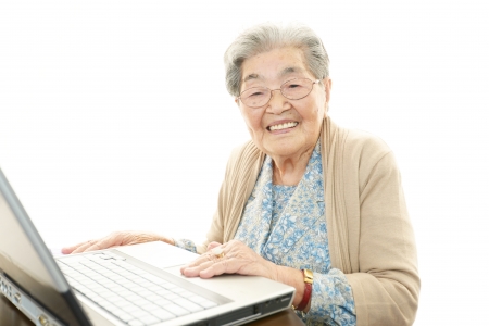 Old woman enjoys computerの写真素材