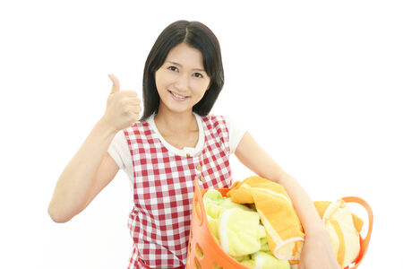 The woman is holding a laundry basketの写真素材