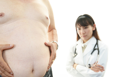 Serious doctor examining a patient obesityの写真素材