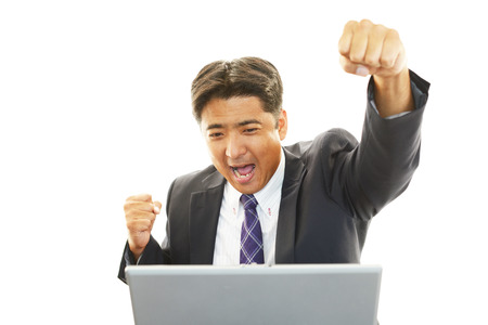 Smiling businessman using laptopの写真素材