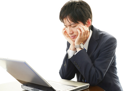 Stress Asian man looking at laptop の写真素材