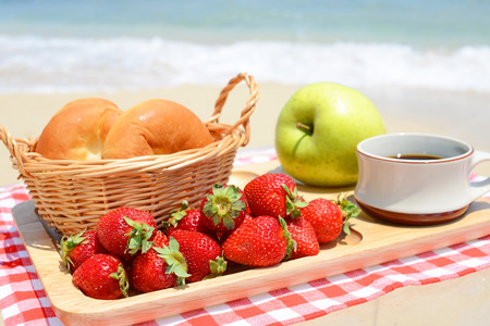 Fruits with breads on the sandy beachの写真素材