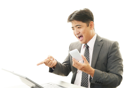 Surprised Asian businessmanの写真素材