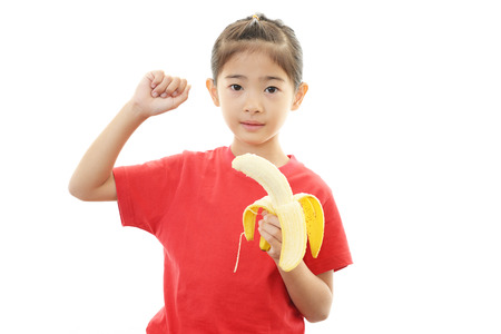 Happy girl eating fruit の写真素材