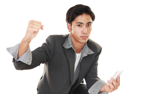 Happy Asian man holding a smart phoneの写真素材