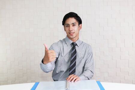 Asian business man showing thumbs up signの写真素材