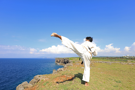 Man practicing karate at beachの写真素材