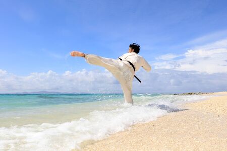 Young man practicing karate at beachの写真素材