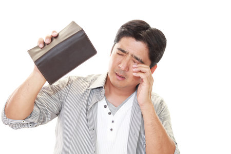 Closeup portrait of stressed, upset, sad, unhappy shocked man, looking into the empty wallet.