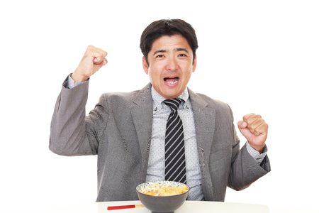Young Asian office worker eating noodle...の写真素材