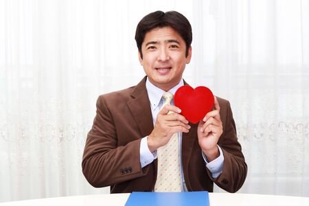 Smiling man with a red heartの写真素材