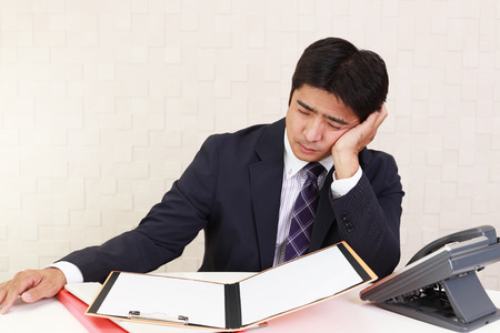 Tired and stressed Asian businessmanの写真素材