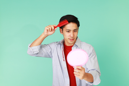 A man taking care of his hairの写真素材