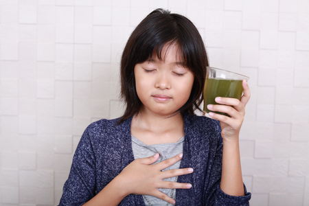 Asian girl drinking a glass of vegetable juiceの写真素材