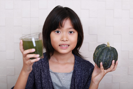Asian girl drinking a glass of vegetable juiceの写真素材