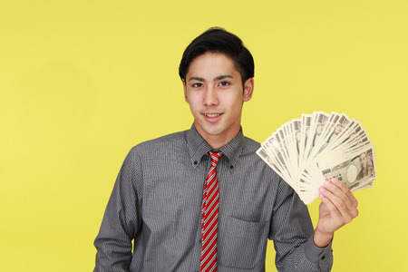 Smiling Asian businessman with moneyの写真素材