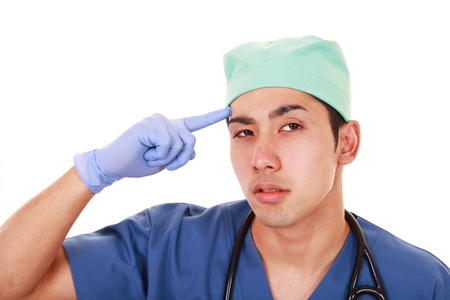 Portrait of an overworked and tired Asian doctorの写真素材