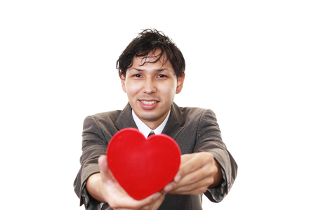 Smiling man with a red heartの写真素材