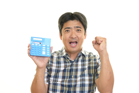 Smiling Asian man with a calculatorの写真素材