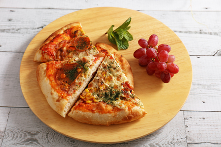 Delicious pizza on a wooden trayの写真素材