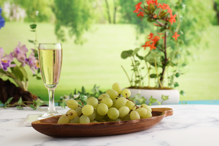 A glass of white wine and grapesの写真素材