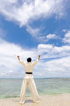 A man practicing karate at the beach.の写真素材