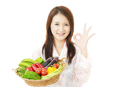 Smiling woman with vegetables.の写真素材