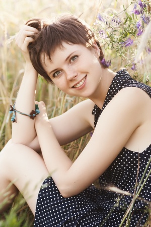 Beautiful smiling girl in dress in field of wheatの写真素材